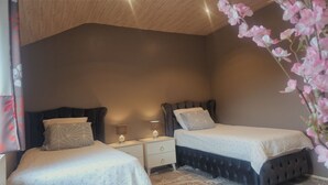 Une chambre avec deux lits, une table de chevet avec une lampe et une plante décorative.
