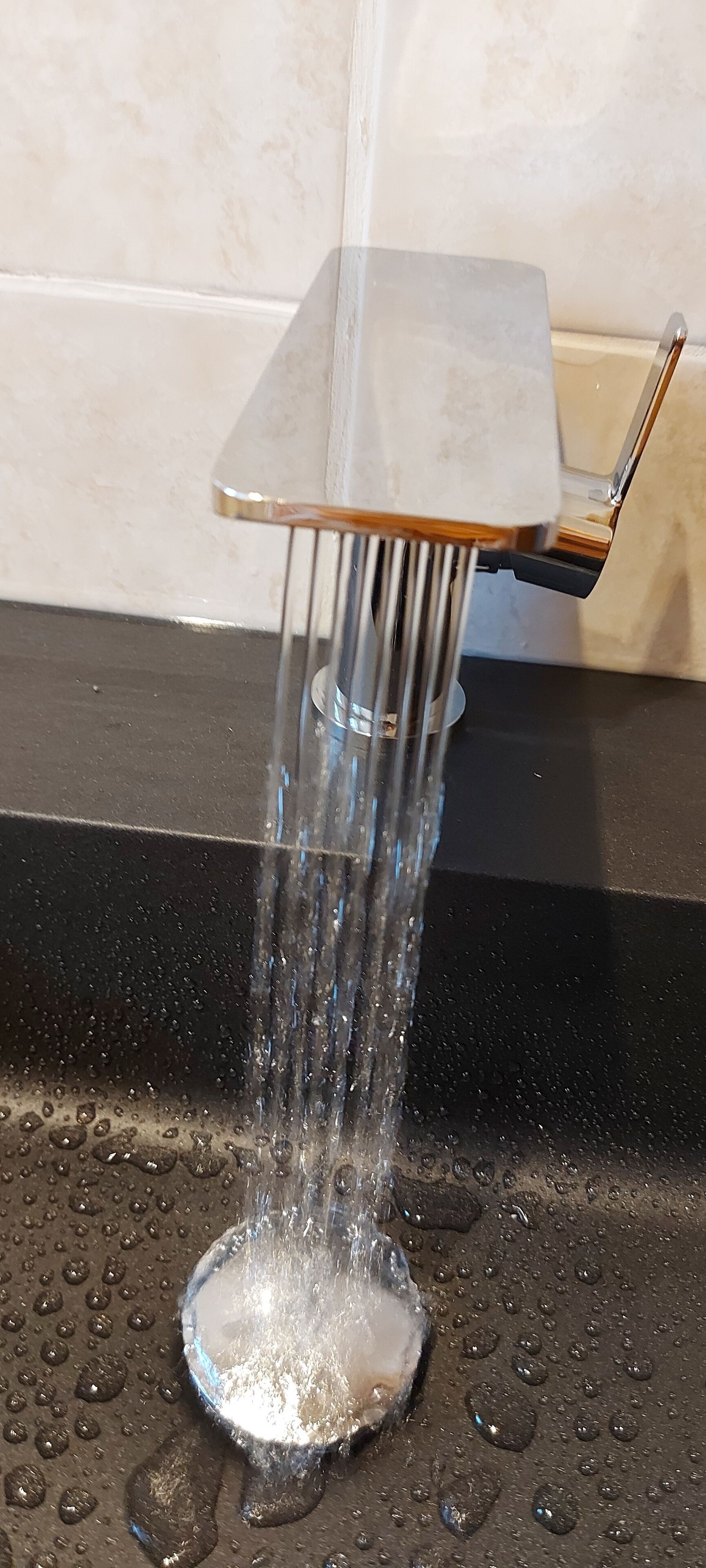 Un robinet d’où coule de l’eau dans un lavabo.