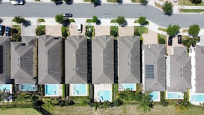 A row of modern apartment buildings with uniform rooflines and small front yards.
