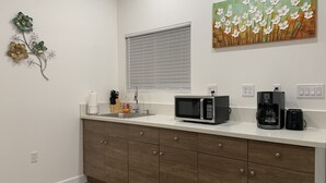 Eine moderne Küche mit Mikrowelle, Kaffeemaschine und Spüle.
