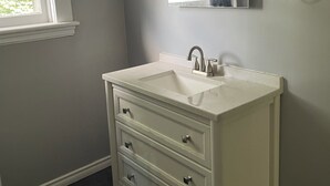 A bathroom with a white vanity, a mirror, and a window. - Spacious house, 5 min walk to downtown- cafes, restaurants, and pubs (Peterborough)