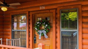 A wooden cabin with a front door, a number '306' above it, and a wreath on the door. - Cozy Cabin for Two near Shows! Whirlpool Tub, Gas Fireplace, Private Balcony (Branson)