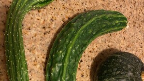 Tre zucchini på en fläckig bänkskiva.