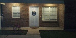 A brick building with a white door, two windows, and a small porch. - Country Stay of Laplace 4 (LaPlace)