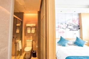 Ein Badezimmer mit einer Duschkabine, einer Toilette und einem Mülleimer.