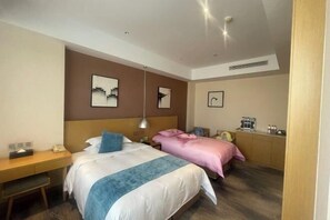 A hotel room with a bed, bedside table, desk, and a small kitchenette area. - Canal Hotel (Jiaxing)
