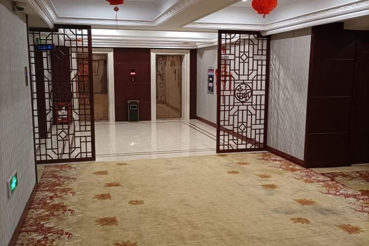 A hotel corridor with a decorative gate, a carpeted floor, and a door leading to a room.