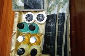 A set of toiletries in a plastic tray with a black and white floral design. - Taihua Hotel (Rugao)