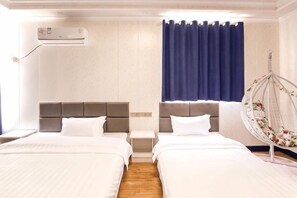 Ein Hotelzimmer mit zwei Betten, einem Hängesessel, einem Nachttisch und einem Fenster mit Vorhängen.