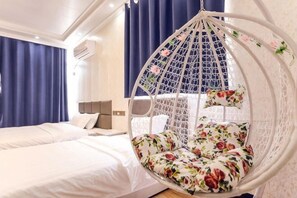 Ein Schlafzimmer mit Hängekorbsessel, Bett und Nachttisch.