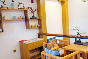 Une pièce comprenant un banc en bois, une table et des étagères ornées d’objets décoratifs.