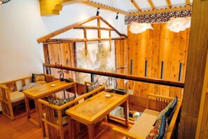 Un interior de madera con comedor, bancos y una ventana con vistas.
