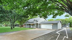 A residential house with a front porch, garage, and a driveway.