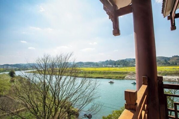 A river view with boats, a wooden railing, and a clear sky. - Youke Susu Hotel (Guiding Yinzhai) (Guiding)