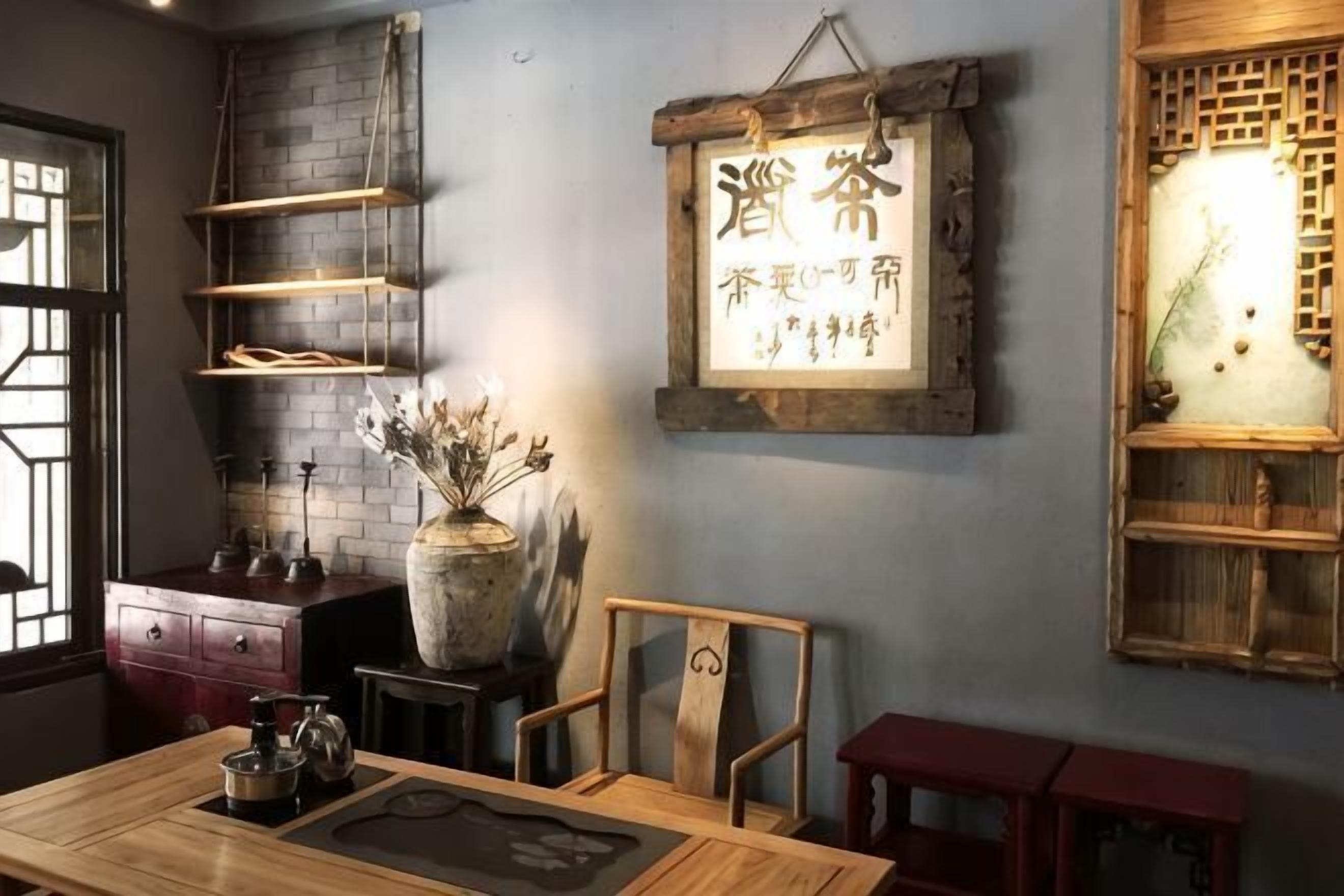 Una habitación con una mesa de madera, sillas, un jarrón con flores secas, estanterías y un letrero con caracteres chinos.