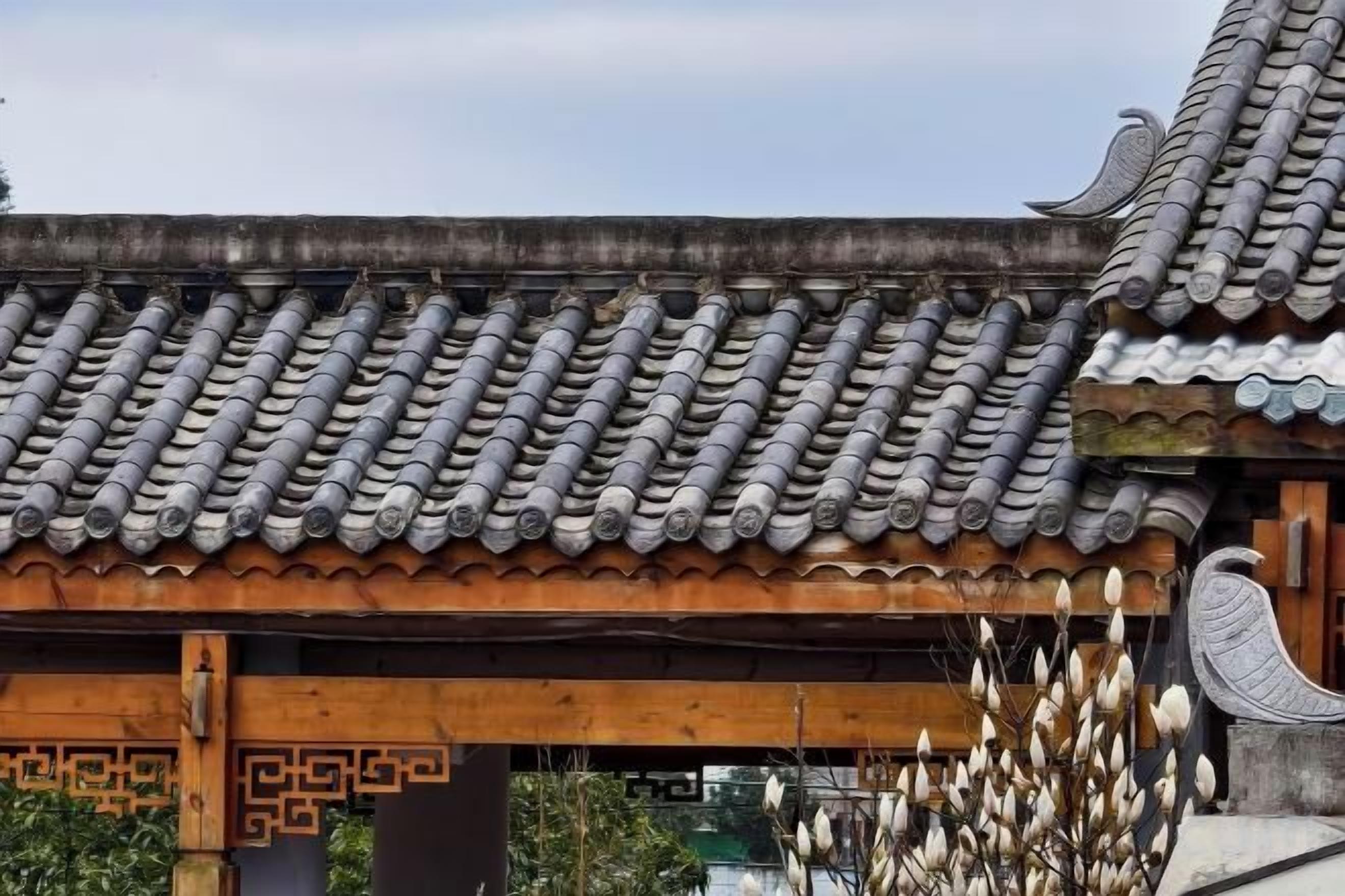 Un toit traditionnel recouvert de tuiles, avec une structure en bois décorative en dessous.