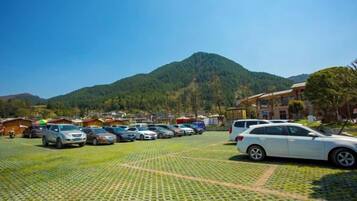 A parking lot with cars and a mountain in the background.