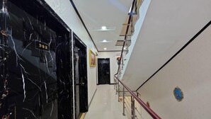 A corridor with a marble floor, a staircase with a red handrail, and a door with the number 302. - Jingxige Inn (Gouqi Island) (Shengsi)