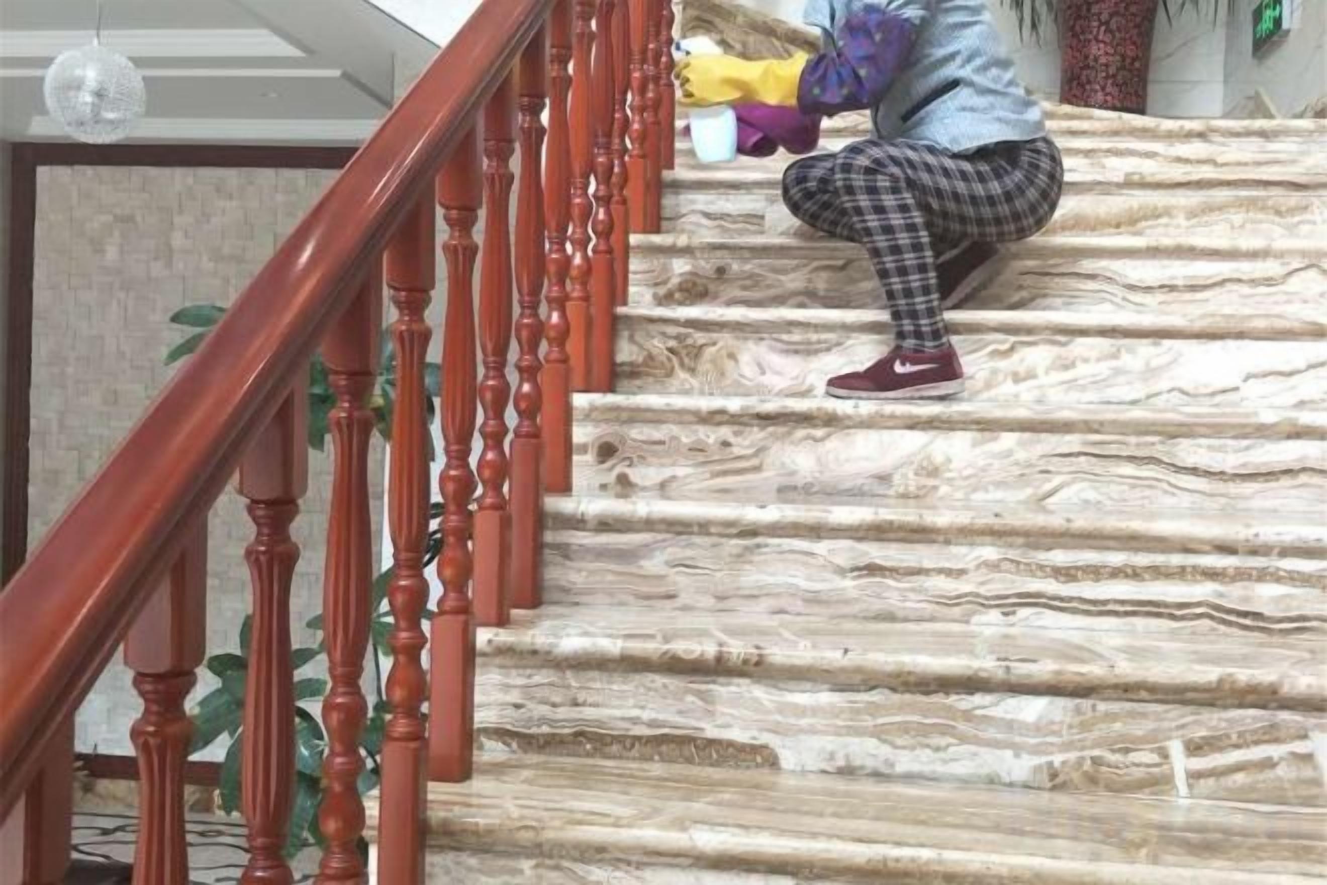 A staircase with a wooden handrail and a person descending.