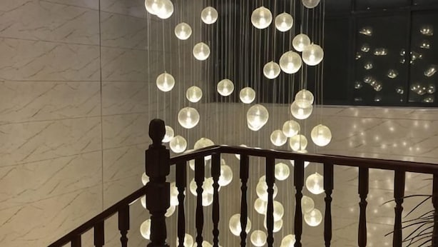 Un escalier doté d’une rampe et de luminaires sphériques suspendus.