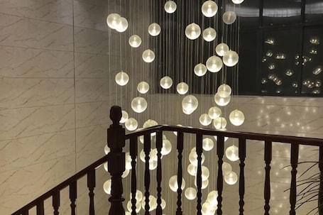 A staircase with a railing and hanging spherical light fixtures.. Youxiang Hotel