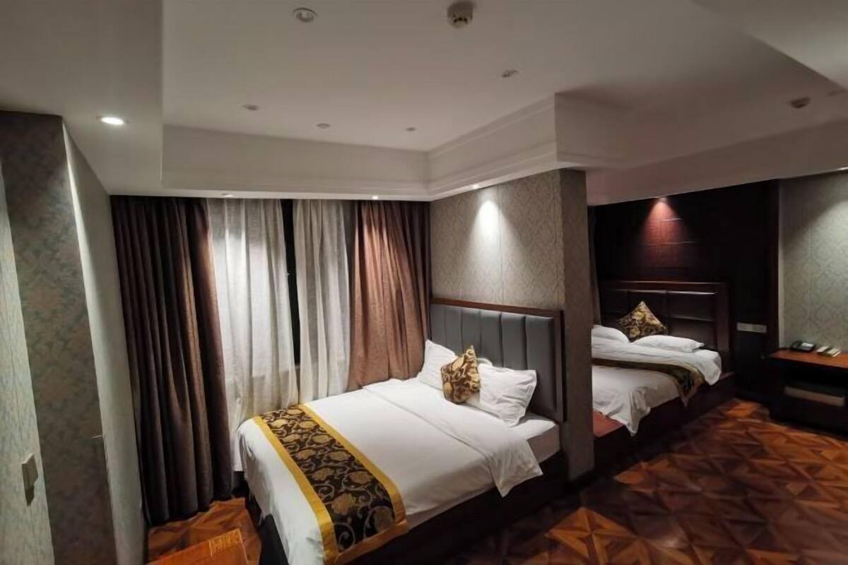 A hotel room with two beds, a wooden floor, and a modern design.