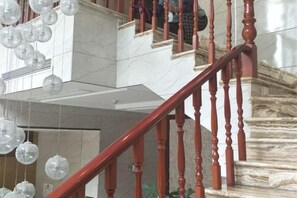 A staircase with marble steps and wooden balusters. - Youxiang Hotel (Wenzhou)