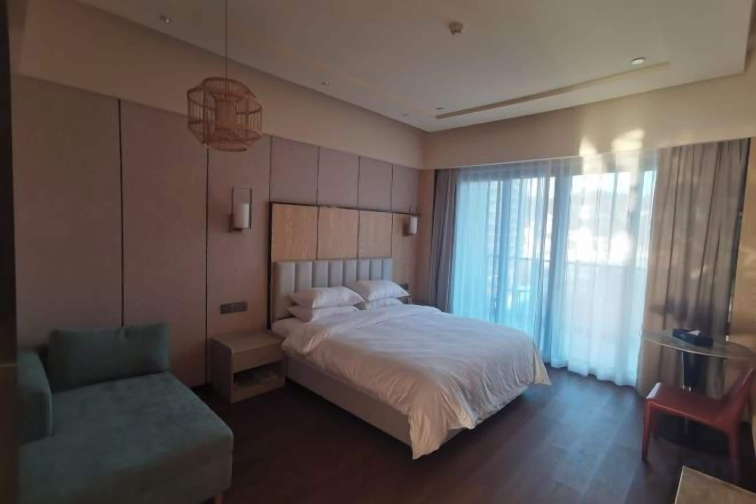 Ein Hotelzimmer mit einem großen Bett, einer Sitzecke und einem Fernseher.