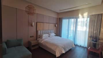 Ein Hotelzimmer mit einem großen Bett, einer Sitzecke und einem Fernseher.