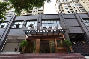 A hotel entrance with a sign in a foreign language, a staircase, and a large window. - Youxiang Hotel (Wenzhou)