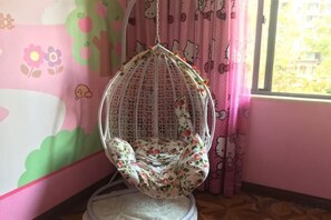 A room with a hanging chair, a window with curtains, and a wall with a floral pattern. - Youxiang Hotel (Wenzhou)