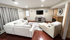 Ein Wohnzimmer mit einer Sofagarnitur, einem Fernseher und einem Kamin.