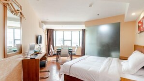A hotel room with a bed, desk, and chair. - Tianlong Boutique Hotel (Ji'an County)