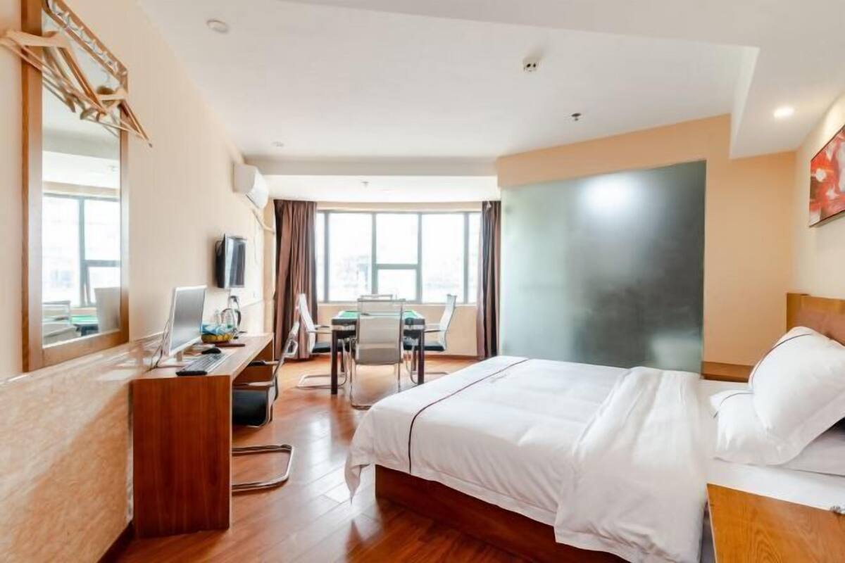 Een hotelkamer met een bed, bureau en stoel.