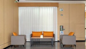 A modern hotel lobby with a sofa set, a coffee table, and a large window with curtains. - Tianlong Boutique Hotel (Ji'an County)