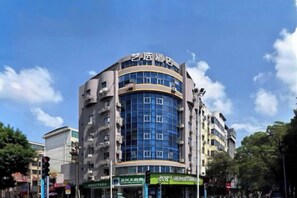 A multi-story hotel with a curved facade, large windows, and signage indicating amenities. - Tianlong Boutique Hotel (Ji'an County)
