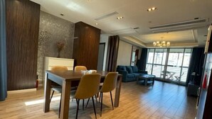 A modern living room with a dining area, large windows, and a chandelier. - Riyueguang Apartment Hotel (Shanghai)