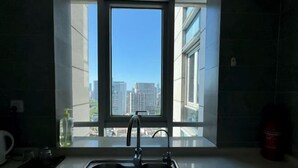 A kitchen with a window, a sink, and a bottle of hand soap on the counter. - Riyueguang Apartment Hotel (Shanghai)