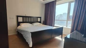 Habitación de hotel moderna con una cama grande, un escritorio y vistas a la ciudad.
