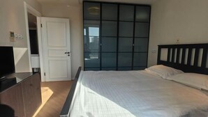 A bedroom with a bed, a wardrobe, and a TV. - Riyueguang Apartment Hotel (Shanghai)