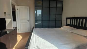 Un dormitorio con cama, armario y televisión.