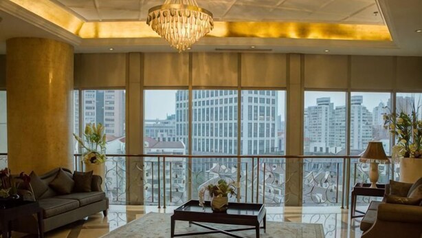 A spacious living room with a large window, a chandelier, and a sofa. - Riyueguang Apartment Hotel (Shanghai)