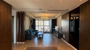 A modern living room with a sofa, coffee table, and a view through large windows. - Riyueguang Apartment Hotel (Shanghai)