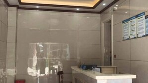 A reception area with a marble counter, a chair, and a red fire extinguisher. - Binhai Hotel, Meili Island, Putian City (Putian)