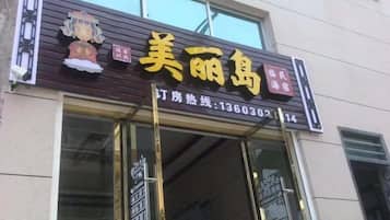 Een winkelgefacade met een bord waarop '美丽鸟' staat en een telefoonnummer '13603021114' voor vragen.