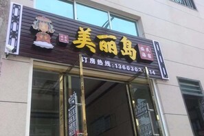 A storefront with a sign that reads '美丽鸟' and a phone number '13603021114' for inquiries.