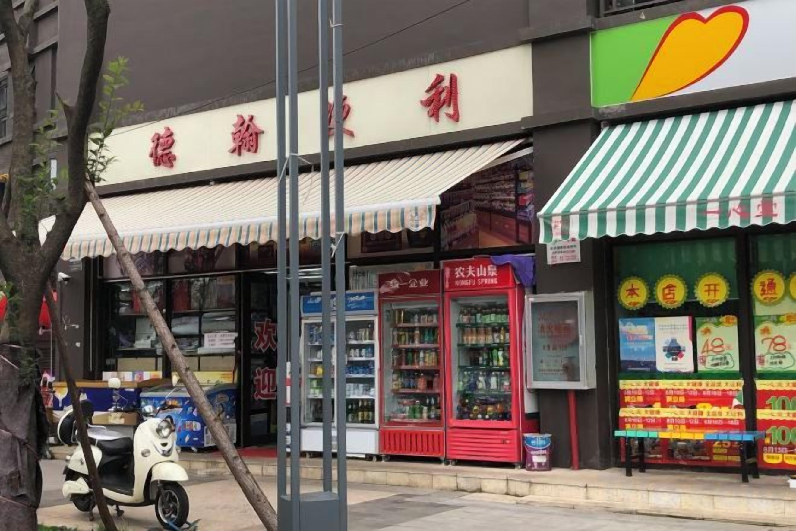 A storefront with a red and white awning, a vending machine, and a sign with Chinese characters.