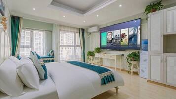 A hotel room with a bed, a desk, a TV, and a wardrobe.