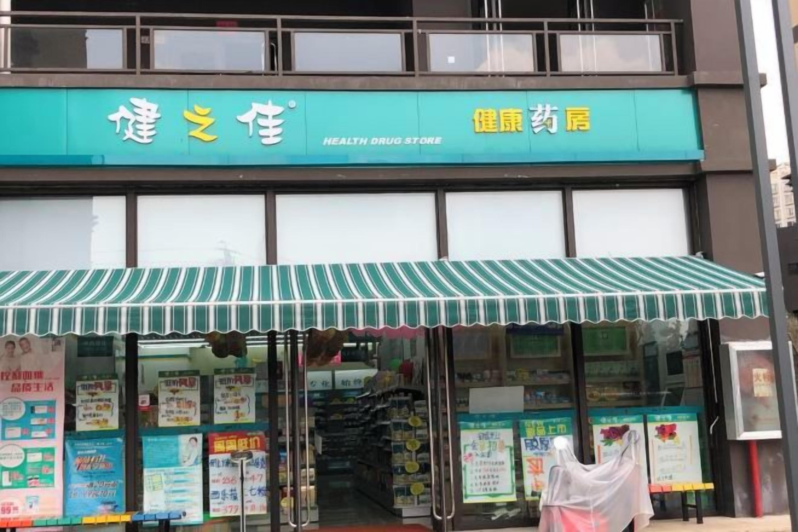 A health drug store with a green awning and multiple informational posters.