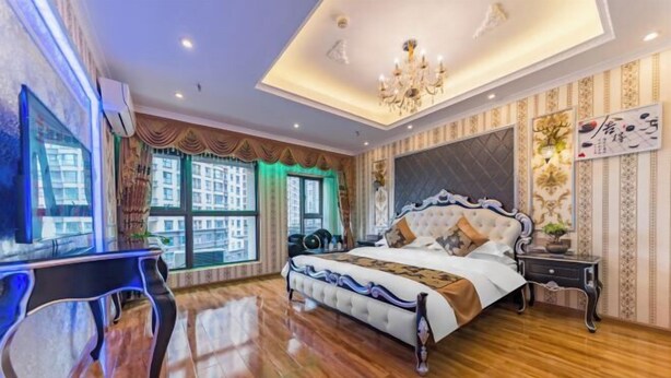 A bedroom with a large bed, a desk, and a window with curtains.